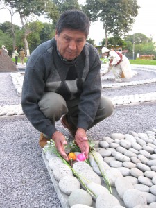 A Peruvian man embracing the symbol of his loved one whose life was ended due to terrorism and acts of violence.
