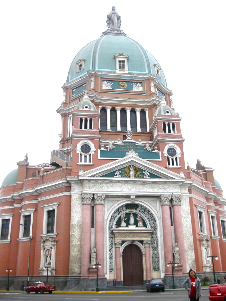  We went to the Santa Maria Magdalena Catholic Church in Magdalena, a district of Peru. Unfortunately, the doors were locked, but we were able to see the church with a closer view. It is beautifully adorned in pink and green with an elaborate dome and a statue of Mary on top. 
