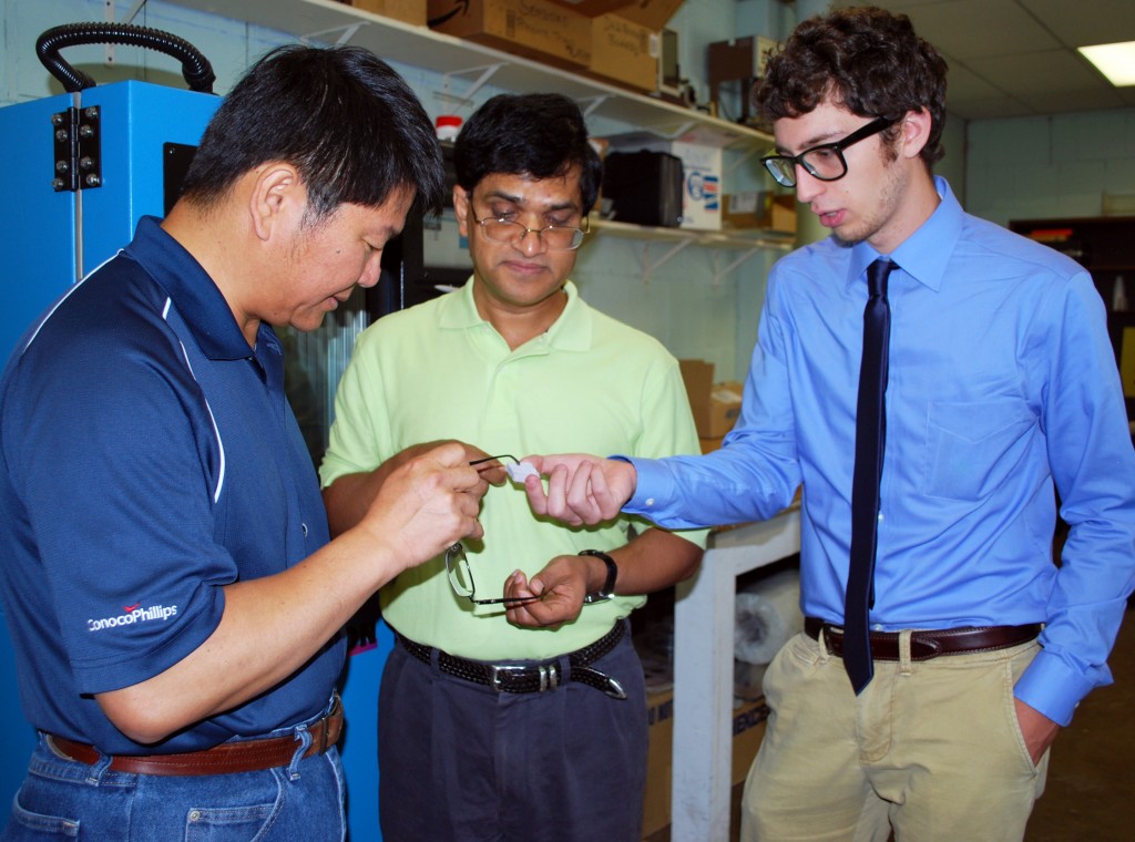 Dr. Chien Pan, Project Manager from ConocoPhillips, Dr. Mrinal Saha, Associate Professor at AME, and Elias Marsee, AME undergraduate researcher, observe tested insulation material.